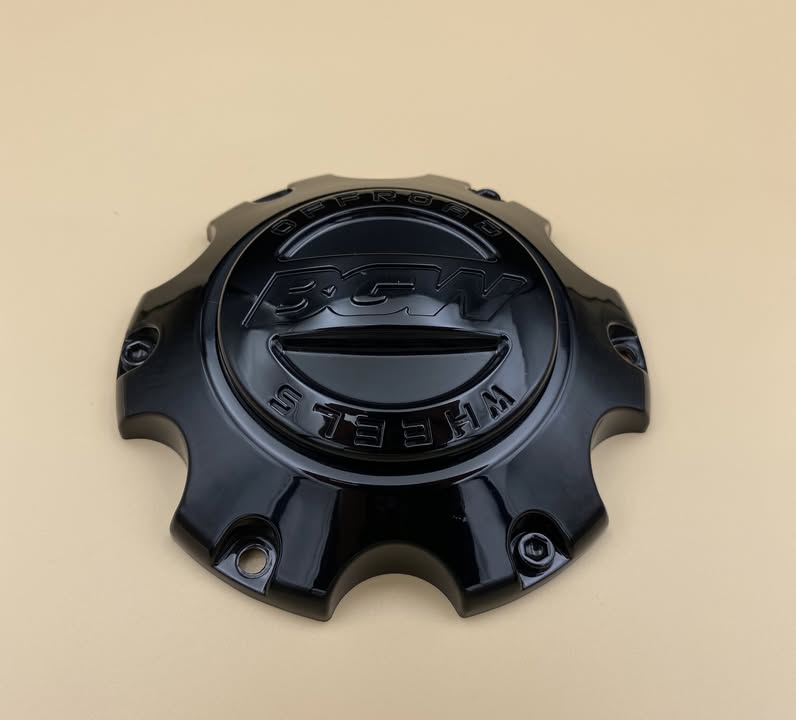 The original black centre cap that came with the aftermarket wheels, with the wheel maker's name moulded into the face
