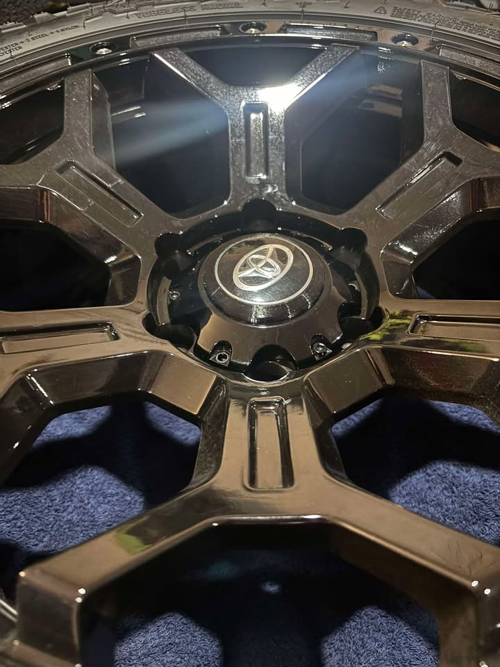 3D printed centre cap holder with a Toyota emblem, fitted to an aftermarket alloy wheel