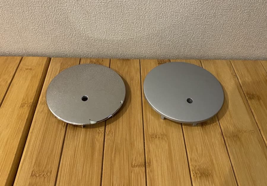 The original chrome shower drain cover with a piece broken out of the rim, next to the 3D printed replacement