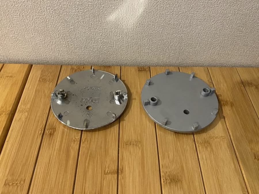 Undersides of both drain covers, showing the matching clip geometry on the printed replacement