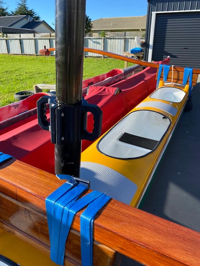 The custom 3D printed handle clamped onto a canoe mast, outdoors on the boat