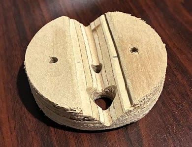 Hand-carved wooden sample of the wall mount, showing the V-groove across the back